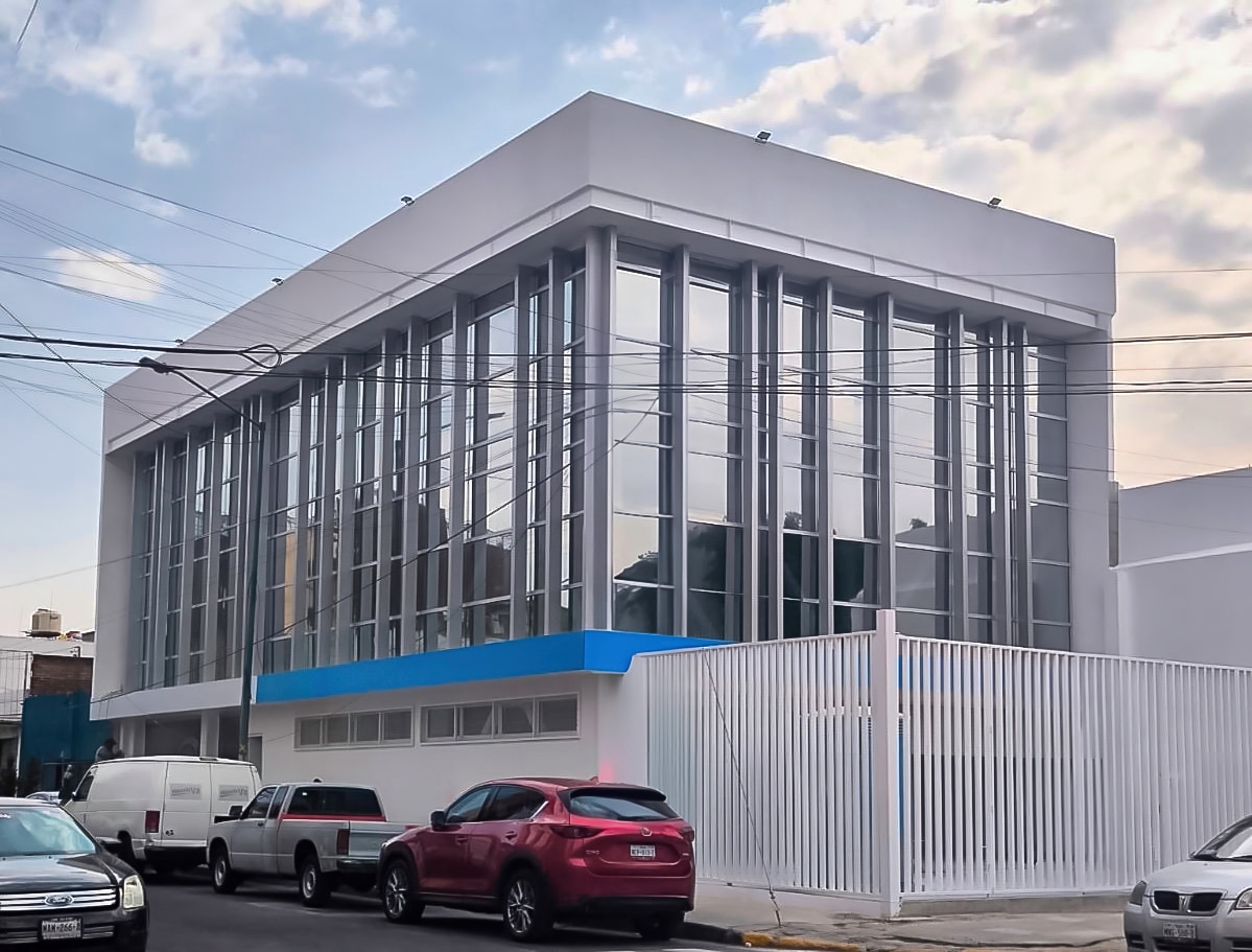Fachada integral serie 450AD con cristal templado reflecta plata y parasoles con panel de aluminio
